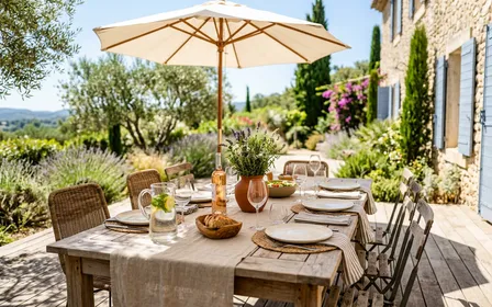 Terrasse de jardin française en bois avec table mise pour le déjeuner d'été et thermomètre indiquant une température élevée sous le soleil de juillet