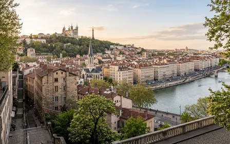 Vue de la Presqu'île de Lyon depuis Fourvière avec immeubles haussmanniens en pierre claire alignés et fleuves Rhône et Saône, lumière dorée d'après-midi