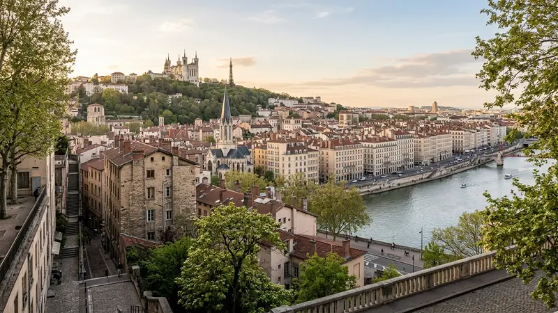 Vue de la Presqu'île de Lyon depuis Fourvière avec immeubles haussmanniens en pierre claire alignés et fleuves Rhône et Saône, lumière dorée d'après-midi