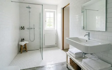 Salle de bain française claire moderne avec faïence blanche impeccable et lavabo en porcelaine, ambiance sobre lumière naturelle douce de fin de matinée, aucun humain ni insecte visible