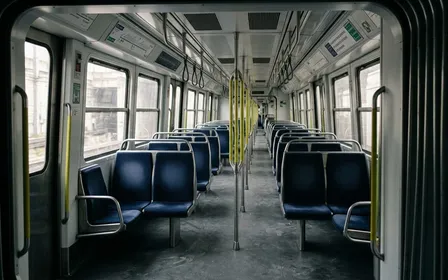 Rame de métro parisien contemporain avec sièges en tissu bleu alignés et fenêtres carrées vue depuis l'entrée du wagon, ambiance sobre lumière naturelle documentaire aucun humain visible plan large