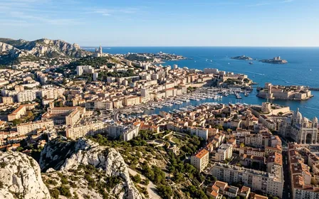 Vue panoramique aérienne de Marseille avec collines calcaires blanches et façades ocre méditerranéennes en fin d'après-midi ensoleillé d'automne avec ciel bleu clair et mer Méditerranée en arrière-plan, ambiance sobre lumière naturelle documentaire aucun humain visible plan large horizontal
